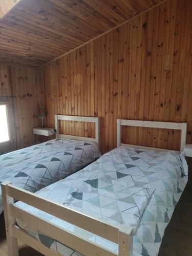 a bedroom with a large bed in a wooden room at maison à la campagne in Sauveterre-de-Guyenne