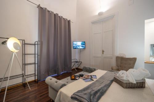 a living room with a bed and a television at Le suite di Alba in Palermo