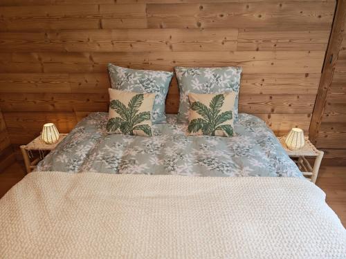 une chambre avec un lit avec deux oreillers dans l'établissement Chalet Toscane avec bain nordique, à La Bresse