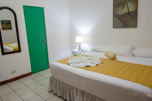 a bedroom with a large bed with a green door at La Posadita de Bolonia in Managua