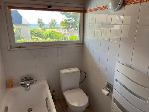 a bathroom with a toilet and a window and a tub at Villa en bord de mer 6 personnes, à côte du Château des Tourelles, piscine d'eau de mer in Pornichet