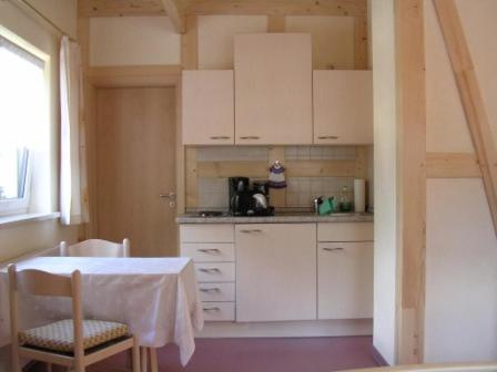 a kitchen with white cabinets and a table and chairs at Haus 'Annelies' in Kurort Rathen