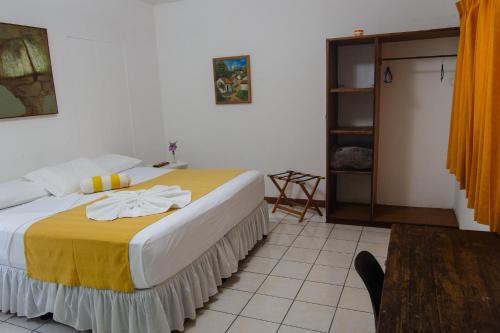 a bedroom with a bed with yellow and white sheets at La Posadita de Bolonia in Managua