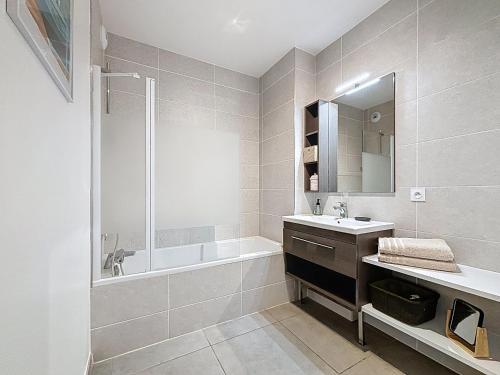 une salle de bain avec une baignoire, un lavabo et une douche dans l'établissement L'Instant paisible, à Brison-Saint-Innocent