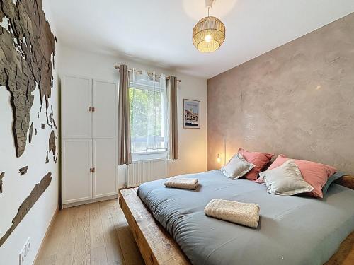 une chambre avec un lit avec des oreillers dessus dans l'établissement L'Instant paisible, à Brison-Saint-Innocent