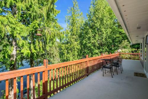 a porch with chairs and a table on a fence at Exclusive Lakefront For 10 with Sauna Kayaks Peace in Snohomish