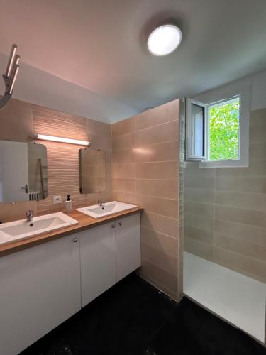 une salle de bain avec deux lavabos et une fenêtre dans l'établissement Gîte 6 personnes Aubenas, à Saint-Didier-sous-Aubenas