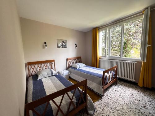 deux lits dans une chambre avec une fenêtre dans l'établissement Gîte 6 personnes Aubenas, à Saint-Didier-sous-Aubenas