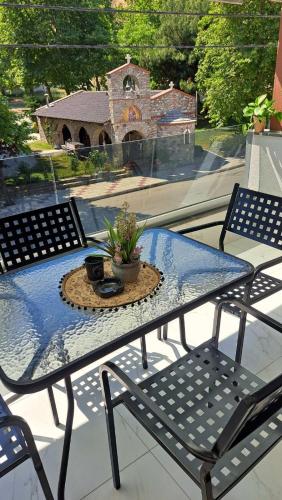 a patio table with a potted plant on a balcony at Sunday Apartment in Néa Péramos
