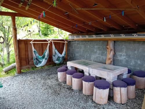 a picnic table and stools under a pavilion at Zakątek Włóczykija in Cisna