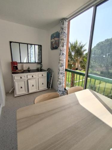 une salle à manger avec une table et une grande fenêtre dans l'établissement Studio - La baie des anges, à La Ciotat