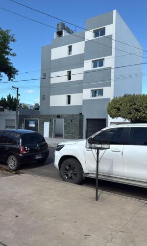 two cars parked in a parking lot in front of a building at Junín departamento in Junín