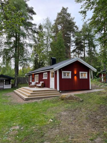 a red cabin with a porch and a deck at Stuga i Falun in Falun