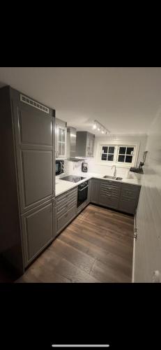 a large kitchen with white appliances and a wooden floor at Stuga i Falun in Falun