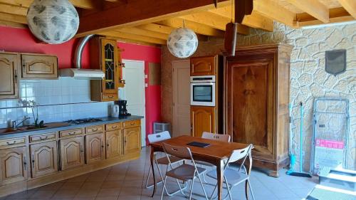 une cuisine avec une table et des chaises en bois dans l'établissement hébergement 3 PERS MAX proche chateaux et zoo Beauval, à La Celle-sous-Gouzon