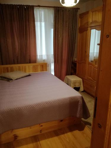 a bedroom with a wooden bed and a window at Apartment Beti in Devin