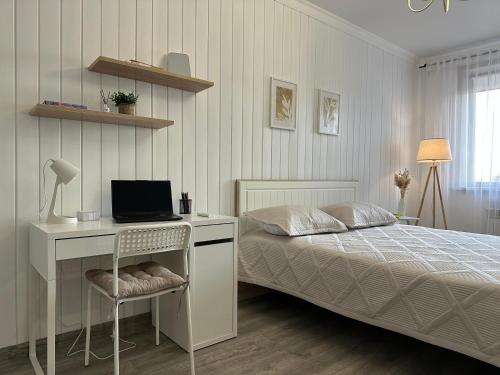Un dormitorio con una cama y un escritorio con una computadora. en ЖК "Light House", 2, en Astana