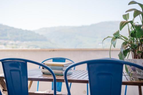 a table with two chairs and a table with books on it at Lousã Varandas House in Lousã