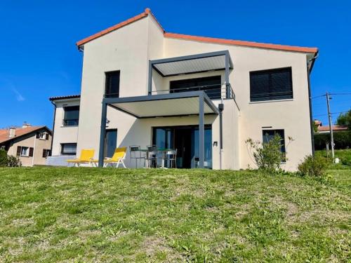 a large white house on top of a green field at Perle de vue in Glaine-Montaigut