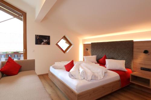 ein Schlafzimmer mit einem Bett mit roten und weißen Kissen in der Unterkunft Ferienhof Kasparbauer in Radstadt