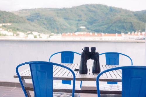 a table and chairs with binoculars on top of a boat at Lousã Varandas House in Lousã