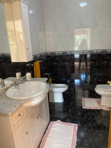 a bathroom with two sinks and a toilet and a mirror at Cantinho da Paula in Monção
