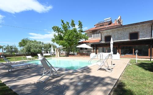 una piscina con sillas y una casa en Maiano Relais, en Suio