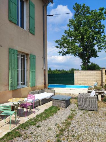 un patio avec une table et des chaises à côté d'un bâtiment dans l'établissement Chambre 3 personnes avec salle de bain dans mas du Lubéron, à Robion