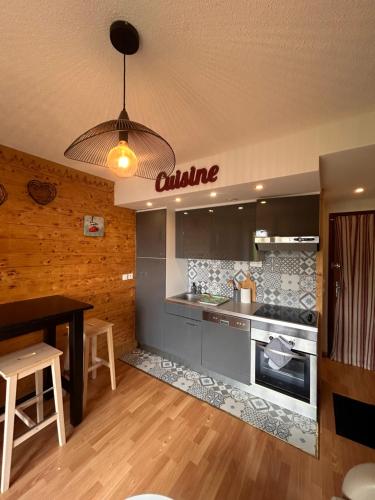 une cuisine avec une cuisinière et un comptoir dans l'établissement Appartement T2 pour 6 pers avec Balcon, Parking et Casier à Ski proche des commerces, aux Angles