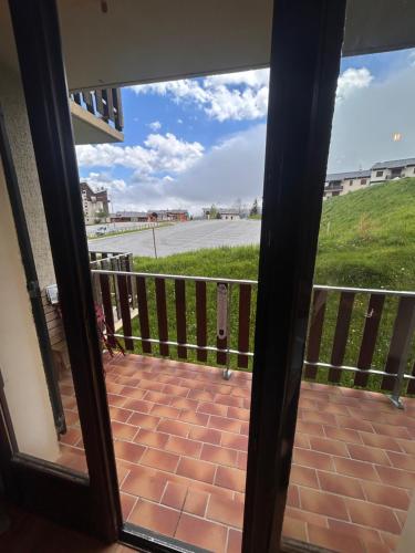 une porte donnant sur un balcon avec vue sur la rue. dans l'établissement Appartement T2 pour 6 pers avec Balcon, Parking et Casier à Ski proche des commerces, aux Angles