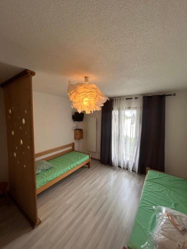une chambre avec un lit vert et un lustre dans l'établissement Appartement T2 pour 6 pers avec Balcon, Parking et Casier à Ski proche des commerces, aux Angles