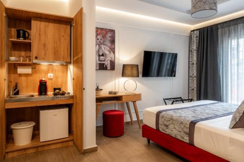 Pokój hotelowy z łóżkiem, biurkiem i umywalką w obiekcie Garment District Suites w Atenach