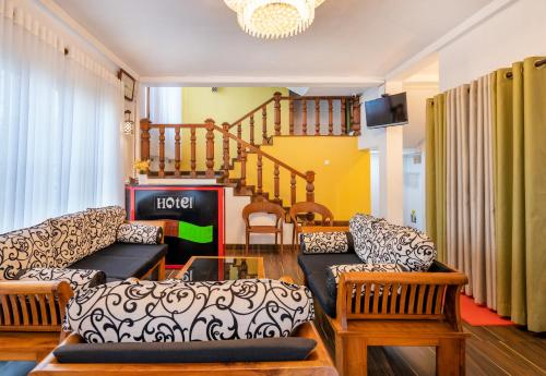 努沃勒埃利耶Villa Grand Mellow Nuwara Eliya的带沙发和椅子的客厅以及楼梯。