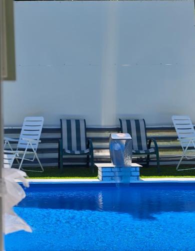 a swimming pool with two chairs and a fountain at Vila N&M in Visoko