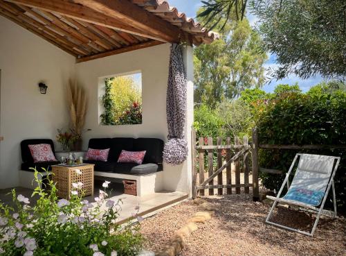 une terrasse avec un canapé et une clôture dans l'établissement Villa Maestro Maria Charme Confort et Accueil Chaleureux à 5 min de la plage, à Lecci