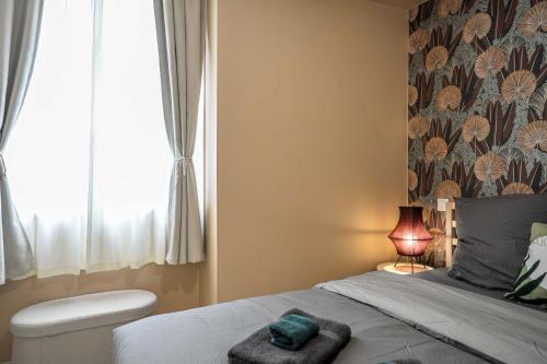 a bedroom with a bed with a towel on it at Bohème Palmeraie - Séjour mystique & unique à Blois in Blois