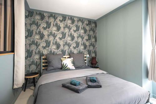 a bedroom with a bed with two towels on it at Bohème Palmeraie - Séjour mystique & unique à Blois in Blois