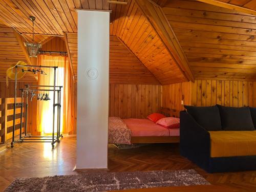 a bedroom with a bed and a couch in a room at Vikendica na Drini in Banja Koviljača