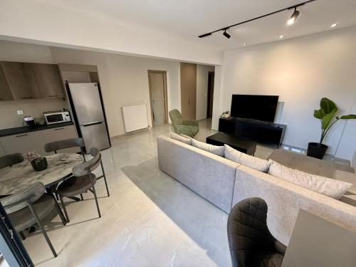 a living room with a couch and chairs and a television at Comfort SpataAir Stay in Spáta