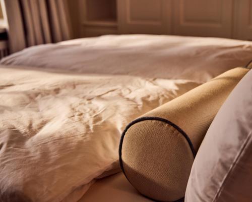 a close up of a bed with white sheets and pillows at Watthüs Morsum mit Kamin und traumhaftem Garten in Morsum
