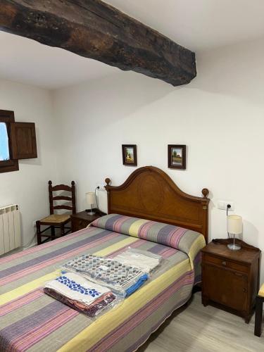 a bedroom with a large bed with a wooden headboard at Casa San Antonio in Albarracín