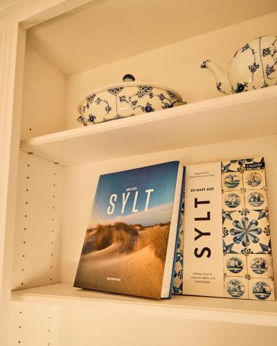a book sitting on a shelf with a book at Watthüs Morsum mit Kamin und traumhaftem Garten in Morsum