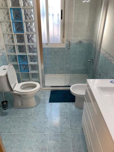 a bathroom with a toilet and a shower and a sink at Cortijo Estrella in Serón