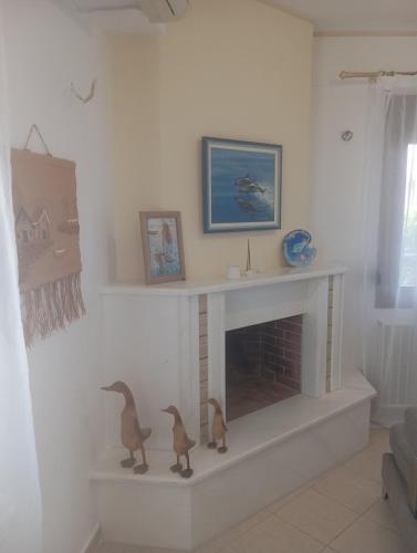 a living room with a fireplace with two ducks on it at Sweet Home in Platamonas
