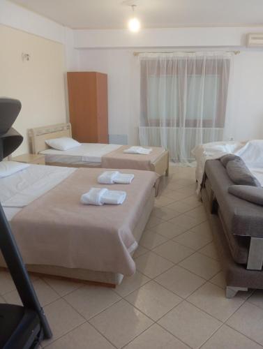 a hotel room with three beds and a window at Sweet Home in Platamonas