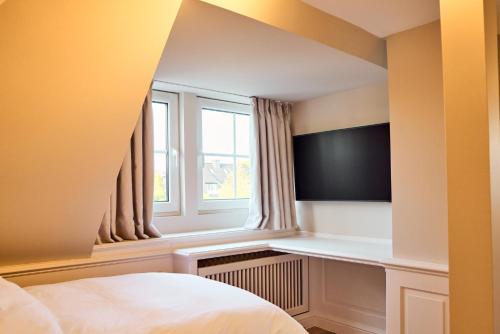 a bedroom with a bed and a window at Watthüs Morsum mit Kamin und traumhaftem Garten in Morsum