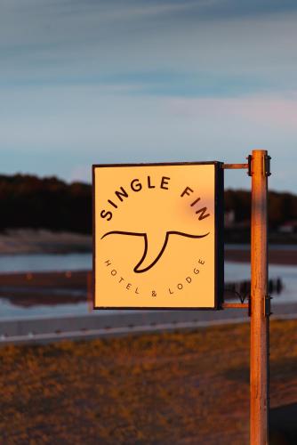 a yellow sign on a pole on a road at Single Fin Hotel & Lodge in Mimizan-Plage