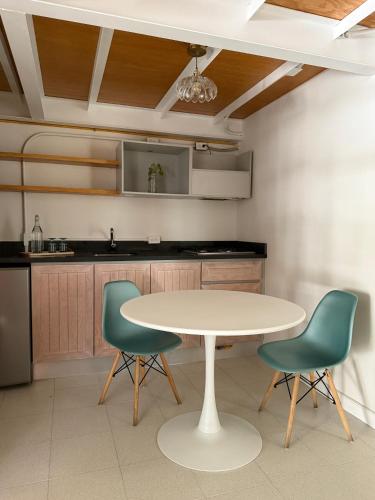 a kitchen with a white table and two green chairs at Casa Moctezuma in Mexico City