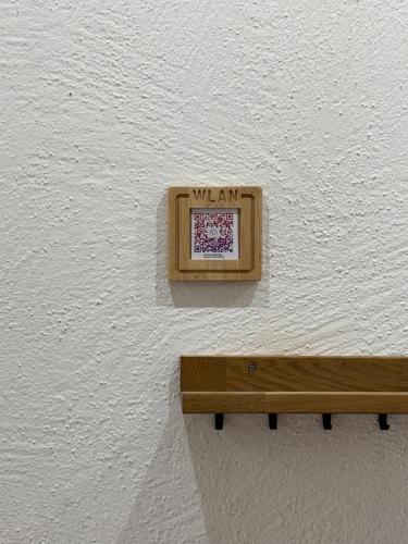 a wooden bench on a wall with a sign on it at Alpenblick - Zentralgelegene 2-Zimmer-Wohnung in Kiefersfelden