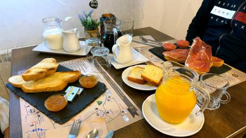 a table topped with plates of food and orange juice at Casa Rural, Spa y restaurante El Huerto del Abuelo in Almiruete